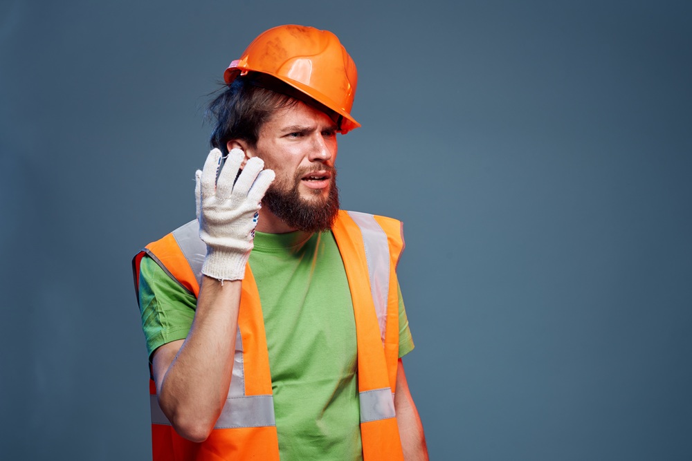 worker man in construction uniform having hearing issues