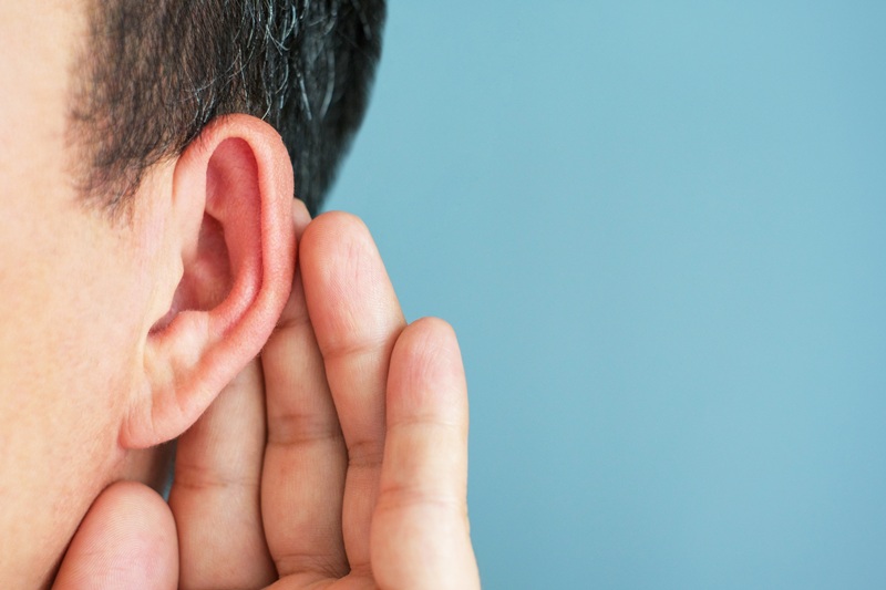 a man focusing on his ears due to hearing loss