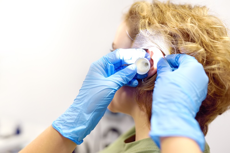 A patient is seen by an otolaryngologist. A professional ENT doctor examines a patient. An otolaryngologist examines a patient's inner ear using an otoscope. Treatment of inflammation disease of ears.