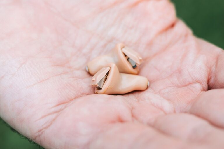 small intra channel hearing aids device in a man's hand