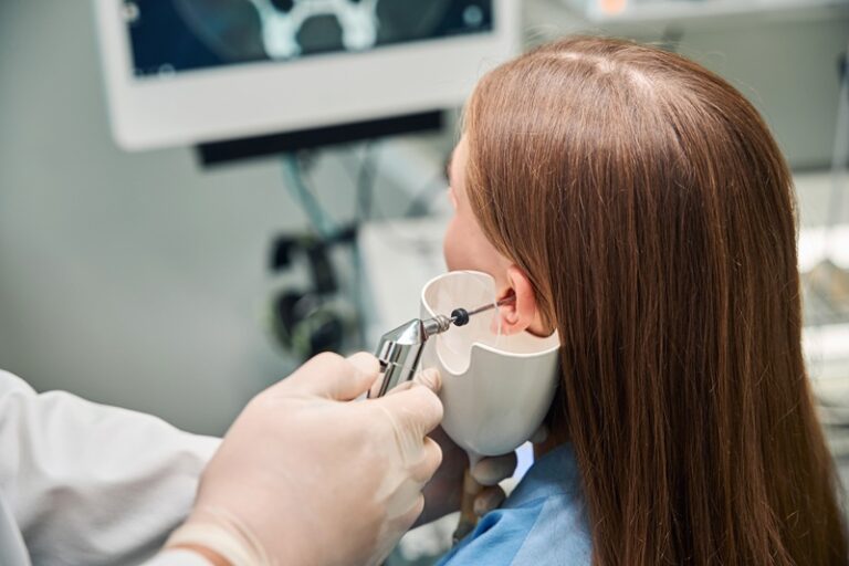 Detailed close-up showing the audiologists conducting ear wax removal by irrigation